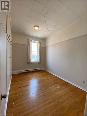 Paris apartment for rent - A room with wooden floors and a window with curtains.