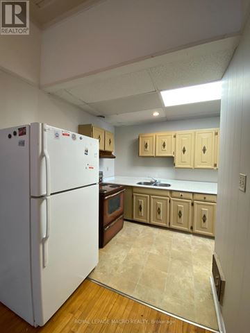 Brant (Paris) townhouse for rent - A white refrigerator is in a kitchen with wooden cabinets.