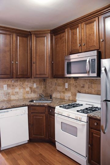 Jersey City apartment for rent - a kitchen with white appliances and wooden cabinets
