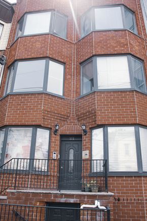 Jersey City apartment for rent - the front of a brick building with a black door and balcony