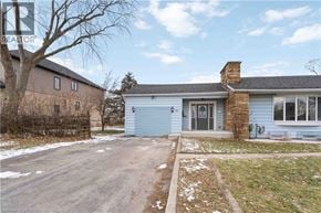 Stoney Creek house for rent - A blue house with a grey garage door is surrounded by a snowy landscape.