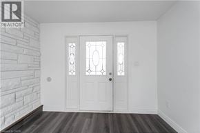 Stoney Creek house for rent - A white door with a glass window is in a room with a brick wall.