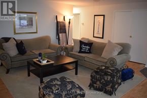 North Kawartha house for rent - A living room with a couch, coffee table, and two pictures on the wall.