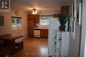 North Kawartha house for rent - A kitchen with a white fridge and wooden floors.