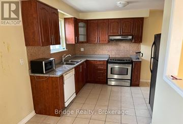 Mississauga (Malton) house for rent - A kitchen with wooden cabinets and stainless steel appliances.