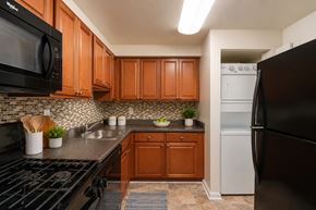 Beltsville apartment for rent - A kitchen with black appliances and wooden cabinets.