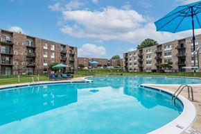 Beltsville apartment for rent - a swimming pool with an apartment building in the background
