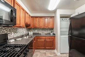 Beltsville apartment for rent - a kitchen with stainless steel appliances and wooden cabinets