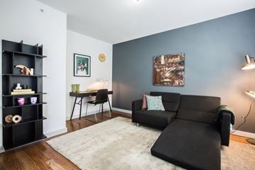 Orange apartment for rent - a living room with a couch and a chair and a desk