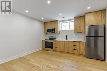 Niagara Falls (Brown) house for rent - A kitchen with wooden cabinets and stainless steel appliances.