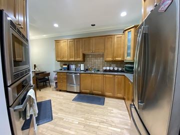 Surrey townhouse for rent - A kitchen with wooden cabinets and a stainless steel refrigerator.