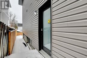 Ottawa house for rent - A snow-covered path leads to a black door with a yellow sign on it.