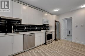 Ottawa house for rent - A kitchen with white cabinets and a black backsplash.