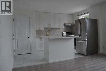 Scarborough apartment for rent - A kitchen with white cabinets and a black refrigerator.