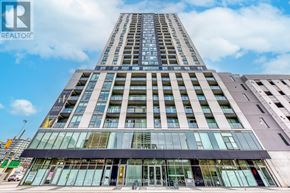 Hamilton (Corktown) multi-family for rent - A tall building with a glass facade and a sign that reads "REALTOR" in the foreground.