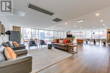 Hamilton (Corktown) multi-family for rent - A spacious living room with a grey sofa and a wooden coffee table.