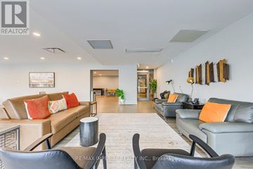 Hamilton (Corktown) multi-family for rent - A living room with a couch, chairs, and a painting on the wall.