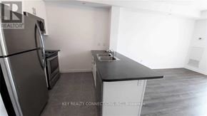 Hamilton (Stoney Creek) condo for rent - A kitchen with a black countertop and stainless steel appliances.