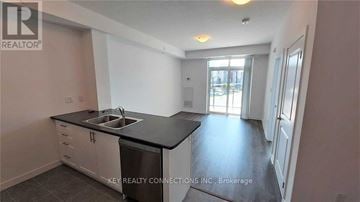 Hamilton (Stoney Creek) condo for rent - A kitchen with a sink and a dishwasher in a room with a door leading to another room.