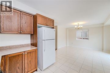Hamilton house for rent - A kitchen with wooden cabinets and a white refrigerator.