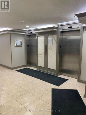 Markham (Royal Orchard) condo for rent - A hallway with two elevators and a sign that says LPF Realty Brokerage.