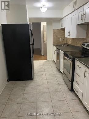 Markham (Royal Orchard) condo for rent - A kitchen with black appliances and white cabinets.