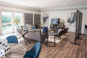 Indianapolis apartment for rent - A living room with a grey couch and a black and white ottoman.