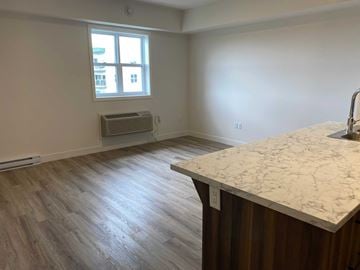 Fredericton apartment for rent - A kitchen with a marble countertop and wooden flooring.