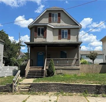 New Kensington apartment for rent - A two-story house with a blue door and a wooden porch.