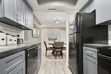 Fort Wayne townhouse for rent - A modern kitchen with a black refrigerator and a dining table with chairs.