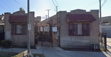 Los Angeles apartment for rent - A street view of a residential area with houses and a parking sign.