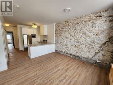 Cambridge other for rent - A kitchen area with wooden floors and a stone wall.