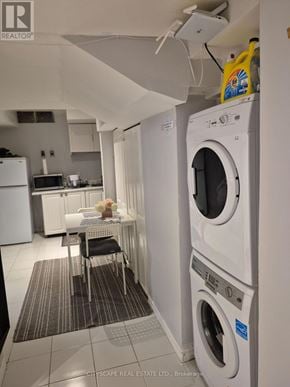Mississauga (Churchill Meadows) house for rent - A white washing machine is in a laundry room with a table and chairs.