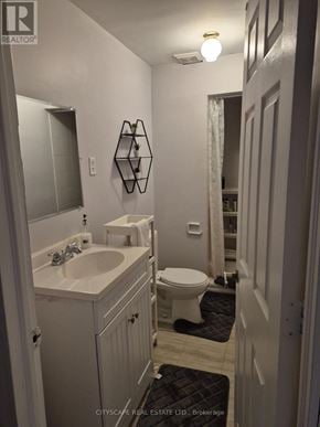 Mississauga (Churchill Meadows) house for rent - A bathroom with a toilet, sink, and mirror.