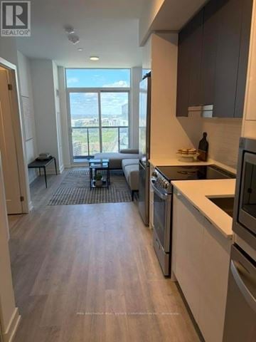 Mississauga (Hurontario) condo for rent - A modern kitchen with stainless steel appliances and wooden flooring.