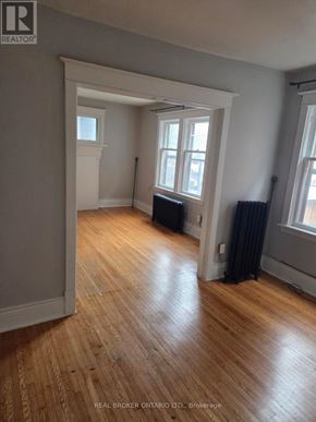 Hamilton (Crown Point) multi-family for rent - A room with wooden floors and a window with black curtains.