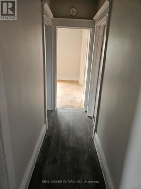 Hamilton (Crown Point) multi-family for rent - A hallway with a Real Broker Ontario Ltd. sign on the bottom.