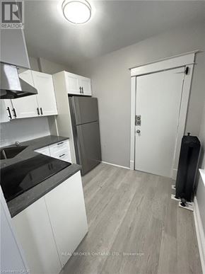 Hamilton (Crown Point) multi-family for rent - A kitchen with white cabinets and a black countertop.