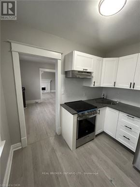 Hamilton (Crown Point) multi-family for rent - A kitchen with white cabinets and a black countertop.