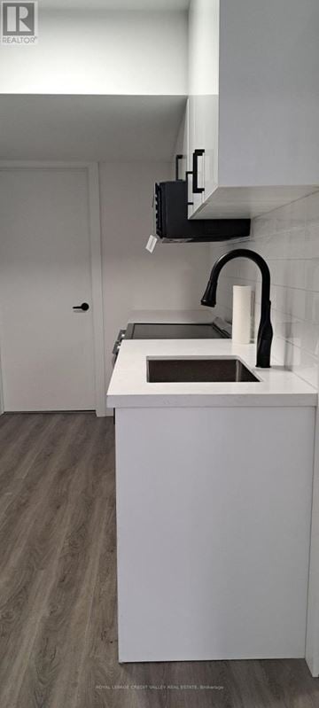 Innisfil (Alcona) house for rent - A white kitchen with a sink and a black microwave.