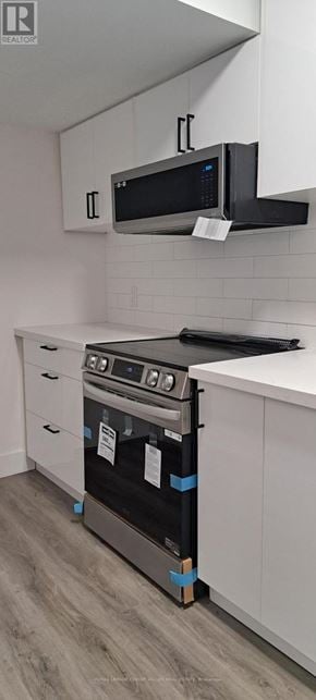 Innisfil (Alcona) house for rent - A modern kitchen with a black oven and white cabinets.