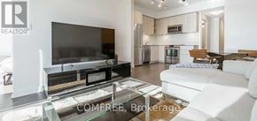 Toronto (Niagara) condo for rent - A modern living room with a flat screen TV and a glass coffee table.