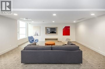 Burnaby apartment for rent - A living room with a grey couch and a red painting on the wall.
