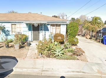 San Diego apartment for rent - A blue house with a white door and windows, surrounded by a garden.