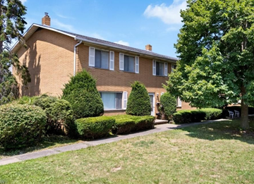 Akron apartment for rent - A house with a brown roof and a green lawn in front.