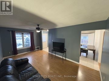 London South (South T) house for rent - A living room with a black leather couch and a flat screen TV.