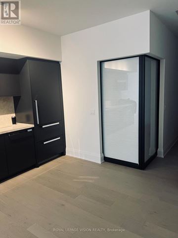 Toronto (Englemount-Lawrence) condo for rent - A modern kitchen with black cabinets and a glass door refrigerator.