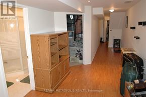 Waterloo townhouse for rent - A room with a wooden cabinet and a green suitcase on the floor.