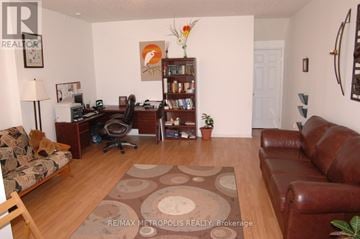 Waterloo townhouse for rent - A living room with a brown leather couch and a brown rug.