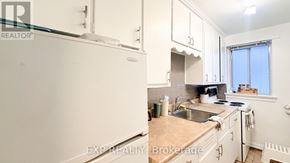 Ottawa multi-family for rent - A kitchen with white cabinets and a white refrigerator.